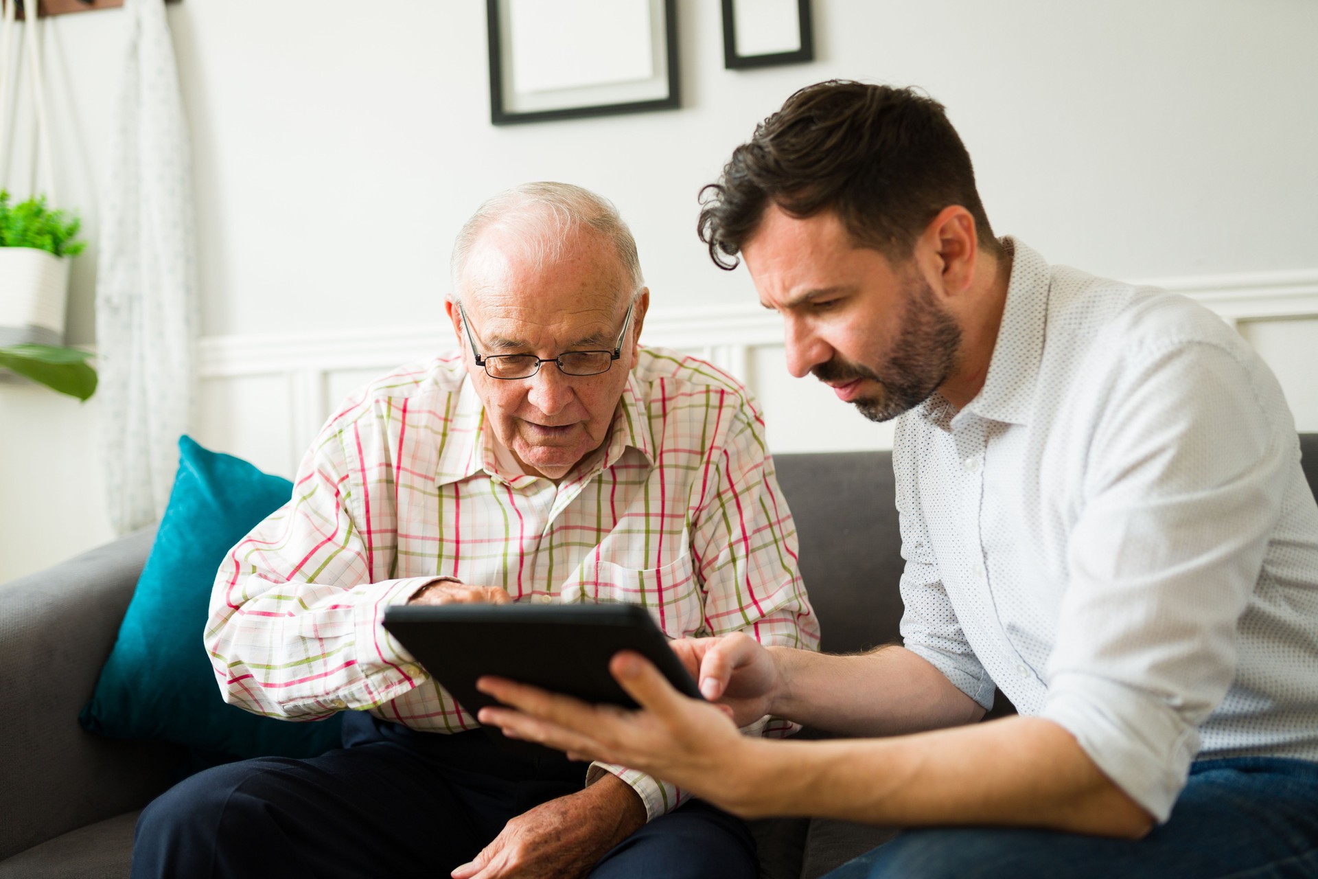 Calgary son helping his senior father to use tablet technology