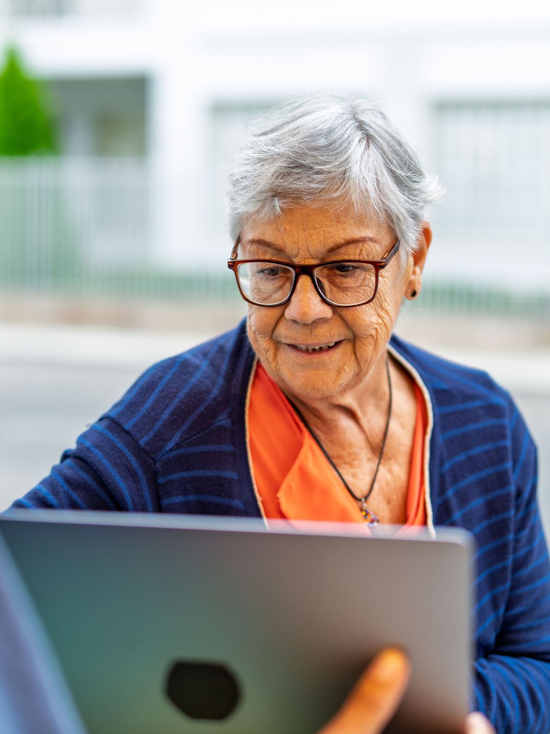 Senior woman smiling while looking at a laptop screen
